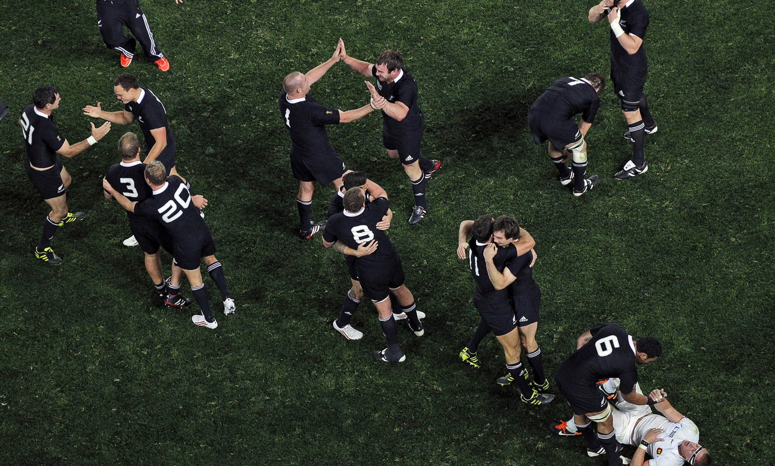 New Zealand All Blacks Jerome Kaino helps up France&#039;s Imanol Harinordoquy as his teammates celebrate after their Rugby World Cup final win over France at Eden Park in Auckland, New Zealand, Sunda ...