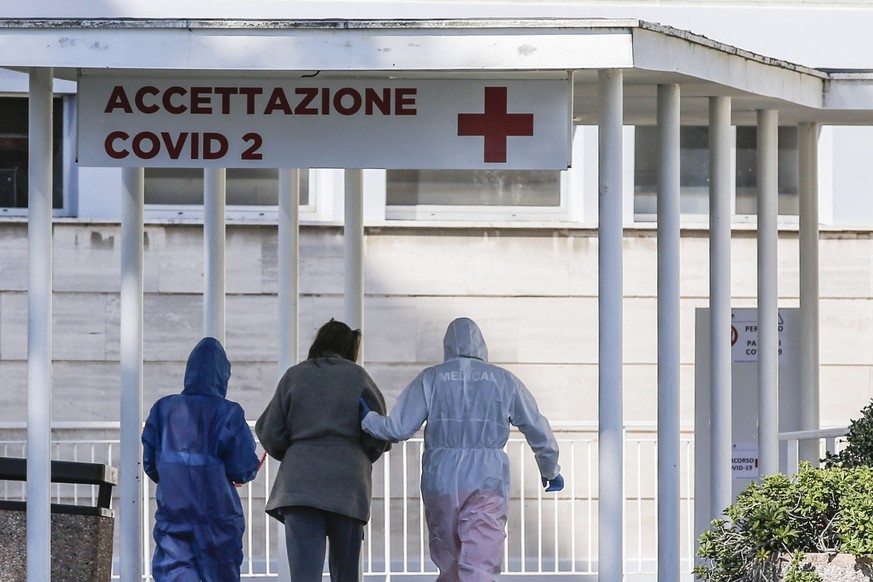 epa08298197 Medical workers in protective suits guide a person into the Columbus hospital unit of the Gemelli hospital at the second Covid center, in Rome, Italy, 16 March 2020. Italy on 15 March 2020 ...