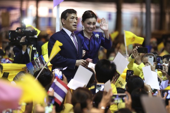Thai King Maha Vajiralongkorn, left and Queen Suthida, right wave to supporters after presiding over the opening of a new mass transit station in Bangkok, Thailand, Saturday, Nov. 14, 2020. (AP Photo/ ...