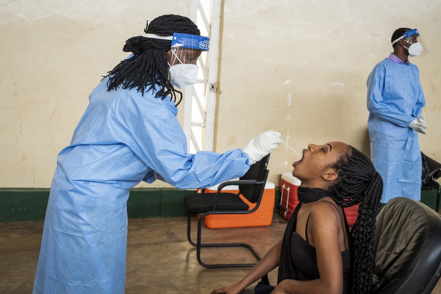 Ruth Irumva, right, is tested for COVID-19 at a testing center in the capital Kigali, Rwanda, Tuesday, July 28, 2020. Like many countries, Rwanda is finding it impossible to test each of its citizens  ...