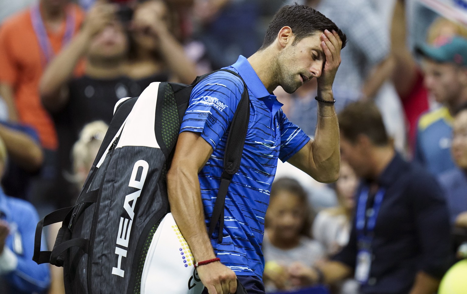 Novak Djokovic, of Serbia, walks off the court as he retires during his match against Stan Wawrinka, of Switzerland, during the fourth round of the U.S. Open tennis championships, Sunday, Sept. 1, 201 ...