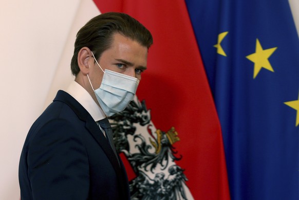 Austrian Chancellor Sebastian Kurz walks wearing a face mask, at the federal chancellery in Vienna, Austria, Sunday, Sept. 13, 2020. The Austrian government has moved to restrict freedom of movement f ...