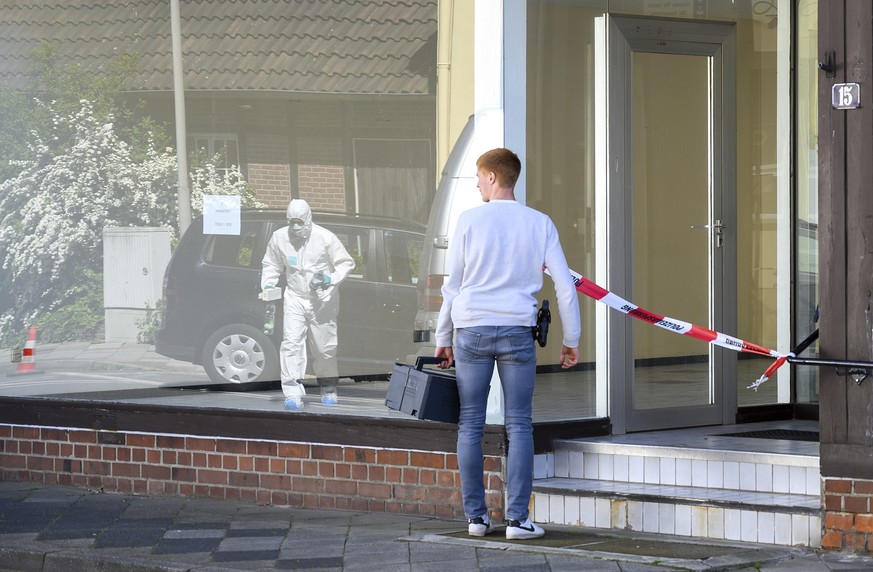 A police officer stands in front of an apartment building where the bodies of two women have been found at an apartment in Wittingen, northern Germany, Monday, May 13, 2019. The women found dead in an ...