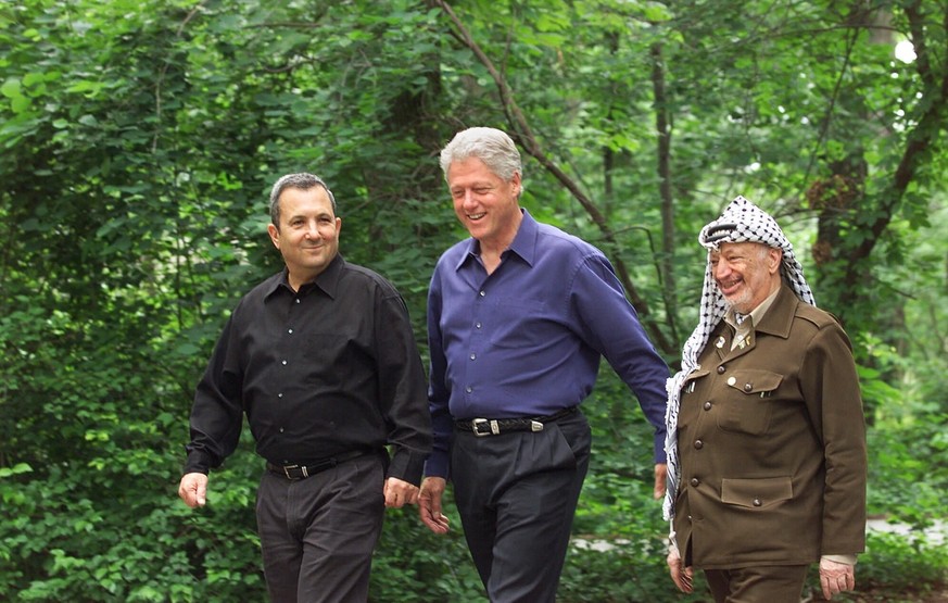 President Bill Clinton, center, Israeli Prime Minister Ehud Barak, left, and Palestinian leader Yasser Arafat walk on the grounds of Camp David, Md., in July 11, 2000, at the start of the Mideast summ ...