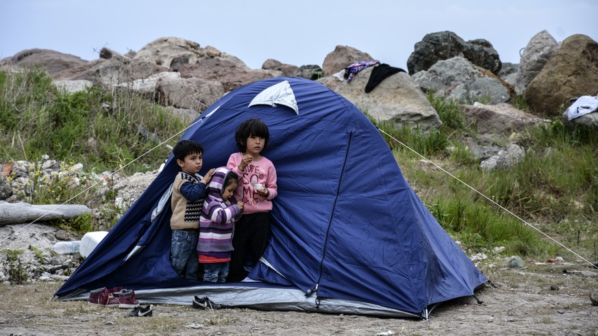 Children stand outside a tent in the village of Petra on the northeastern Aegean island of Lesbos, Greece, Friday, March 27, 2020. Some 56 migrants who reached Lesbos in smugglers&#039; boats from Tur ...