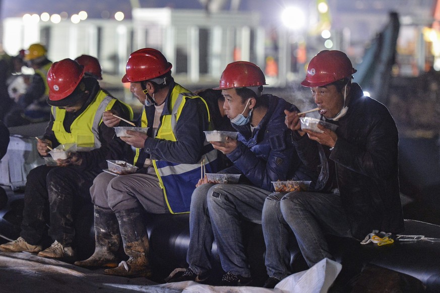In this Tuesday, Jan. 28, 2020, photo, construction workers eat a meal at the site of the Huoshenshan temporary field hospital being built in Wuhan in central China&#039;s Hubei Province. China as of  ...