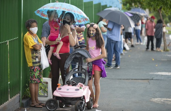 People wait in line outside a public school to get a shot of China&#039;s Sinovac CoronaVac vaccine in Serrana, Sao Paulo state, Brazil, Wednesday, Feb. 17, 2021. Brazil&#039;s Butantan Institute has  ...