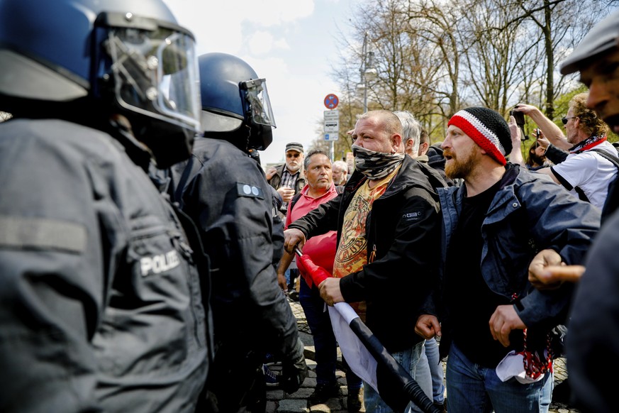 Police officers argues with demonstrators after police stop a protest rally against the German government&#039;s policy to battle the corona virus pandemic in Berlin, Germany, Wednesday, April 21, 202 ...