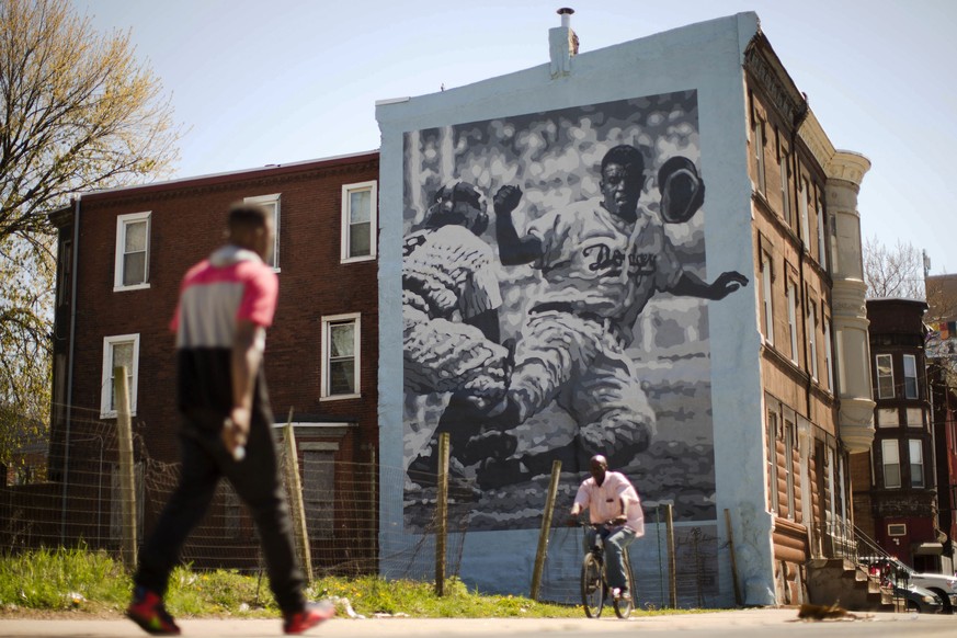 People pass by a Philadelphia Mural Arts Program mural of Jackie Robinson in Philadelphia on Friday, April 15, 2016. On Jackie Robinson Day, Philadelphia is acknowledged its racist treatment of the ba ...