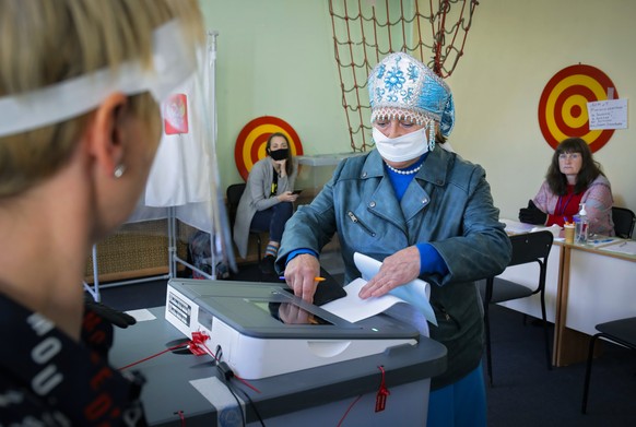 A woman wearing a face mask to protect against coronavirus infection casts her ballot at a poling station during Leningrad region&#039;s governor and municipal elections in Luppolovo village, outside  ...