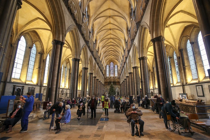 Members of the public receive the Pfizer-BioNTech coronavirus vaccine, at Salisbury Cathedral, in Salisbury, England, Saturday, Jan. 16, 2021. Vaccination centers are being opened in England at some o ...