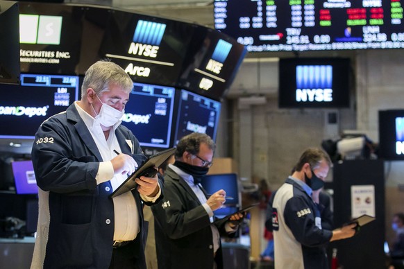 In this photo provided by the New York Stock Exchange, traders work on the floor, Monday Feb. 22, 2021. Investors remain focused on the future of global economies badly hit by COVID-19 and the potenti ...