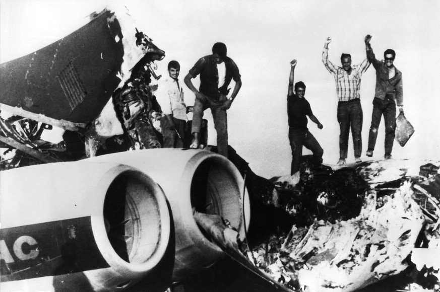 Nach der Entführung sprengten die Entführer drei Flugzeuge in die Luft. Das Bild zeigt sie beim anschliessenden feiern auf den Trümmern.