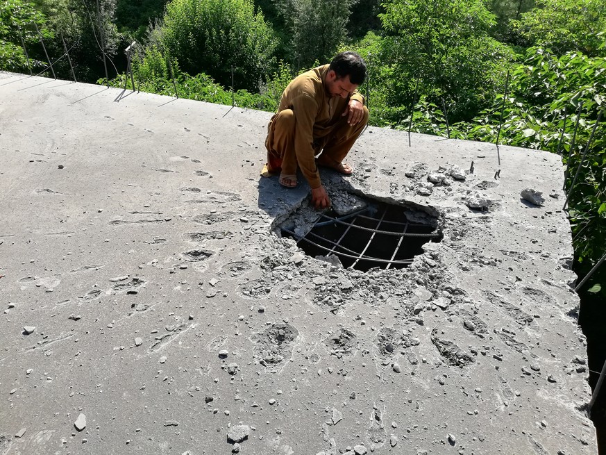 epa07782602 A local resident surveys their house rooftop that was damaged when Indian Army allegedly fired mortal shells from across the Line of Control, the defacto border between Pakistani and India ...