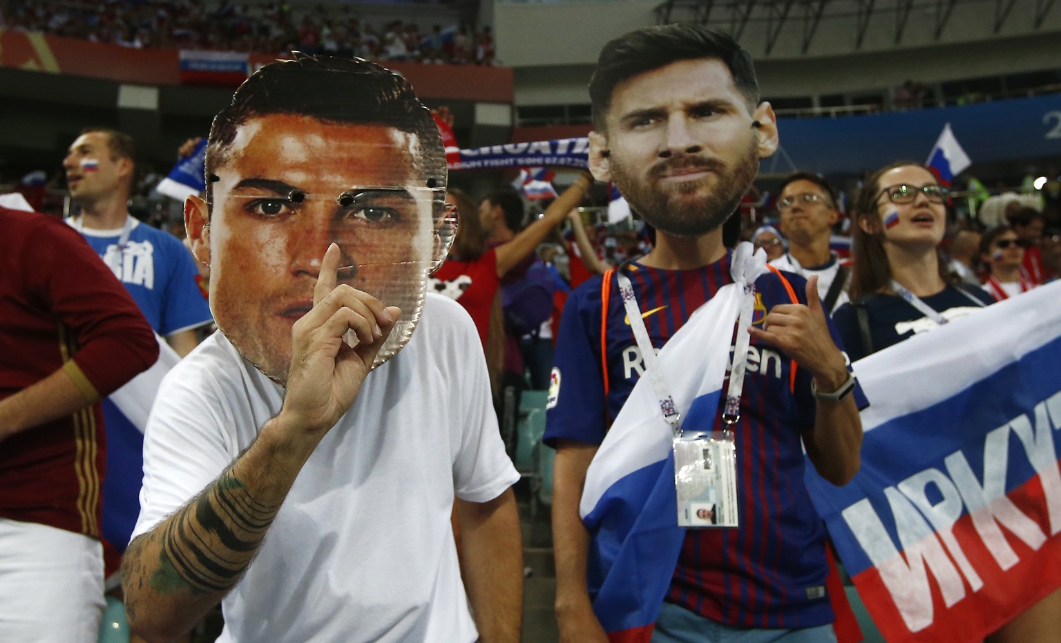 Fans wear masks with the face of the Portuguese national soccer star Cristiano Ronaldo and Argentina national soccer star Lionel Messi prior to the start of the quarterfinal match between Russia and C ...