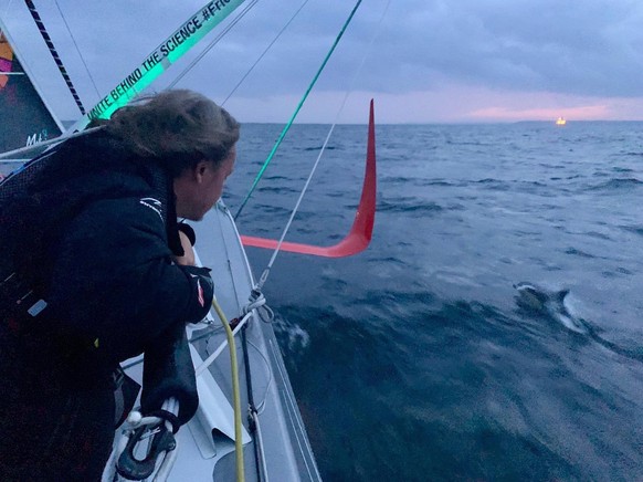 epa07776329 A handout photo made available by Team Malizia shows Swedish climate activist Greta Thunberg watching a doplhin swimming alongside the racing boat Malizia II in the Atlantic Ocean, 14 Augu ...