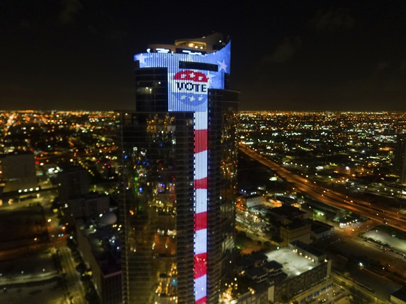 IMAGE DISTRIBUTED FOR WORLD SATELLITE TELEVISION NEWS - America&#039;s largest electronic U.S. flag and an enormous digital &quot;VOTE&quot; lapel button image appear on the 700-foot tall, 60-story, $ ...