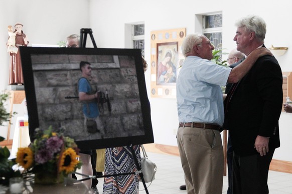 epa04366833 John Foley (R), father of James Foley, is embraced by a man during a memorial service for slain US journalist James Foley at the Our Lady of the Holy Rosary Church in Rochester, New Hampsh ...