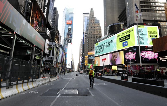 epa08314300 A bicyclist rides through Time Square in New York, New York, USA, 22 March 2020. This week New York Governor Andrew Cuomo issued a statewide shut down of all non-essential businesses and a ...