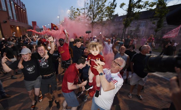 epa08509612 Ecstatic Liverpool FC supporters celebrate outside Anfield stadium in Liverpool, Britain, 25 June 2020. Liverpool have been crowned champions of the Premier League for the first time in th ...