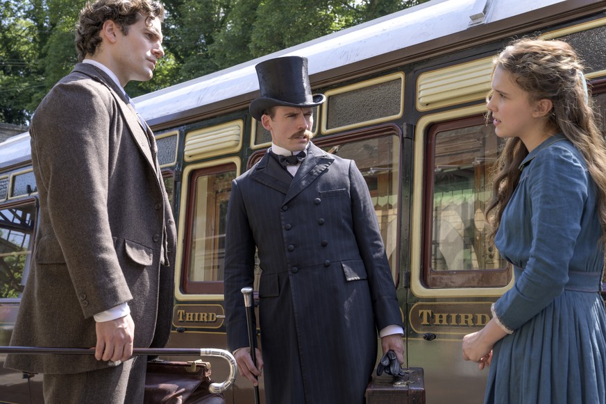 This image released by Netflix shows Henry Cavill, from left, Sam Claflin, and Millie Bobby Brown in a scene from &quot;Enola Holmes.&quot; (Alex Bailey/Netflix via AP)