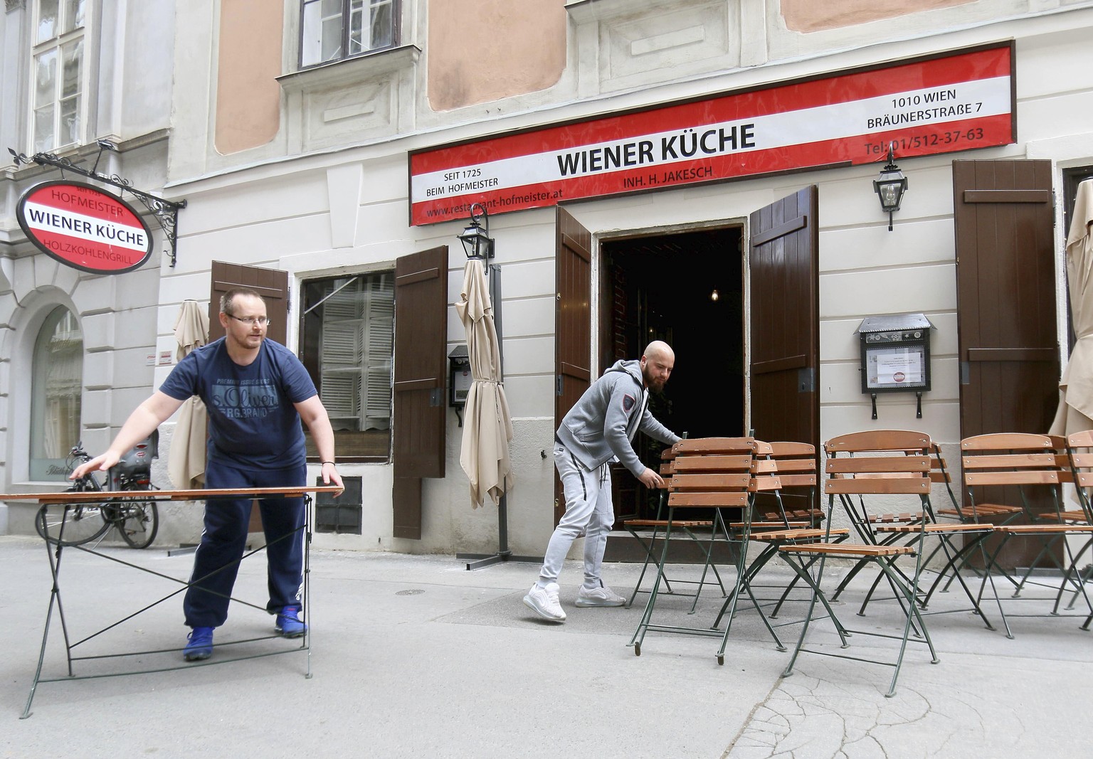 Employees set up tables and chairs in front of a restaurant in Vienna, Austria, Thursday, May 14, 2020. In Austria restaurants may open again under certain conditions from Friday on. The Austrian gove ...