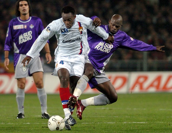 Michael Essien of Lyon, left, fights for the ball with Achille Emana of Toulouse during their French Ligue One soccer match in Toulouse, southwestern France, Saturday, Jan. 31, 2004. (AP Photo/Christo ...