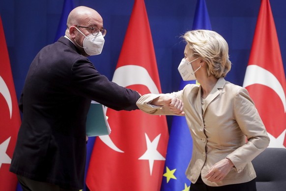 European Council President Charles Michel, left, greets European Commission President Ursula von der Leyen, right, with an elbow bump prior to participating in a video conference meeting with Turkey&# ...