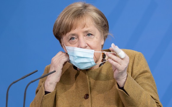 epa09132428 German Chancellor Angela Merkel wears a protective face mask as she arrives for a statement after a cabinet meeting in Berlin, 13 April 2021. The German cabinet in its 137th session agreed ...