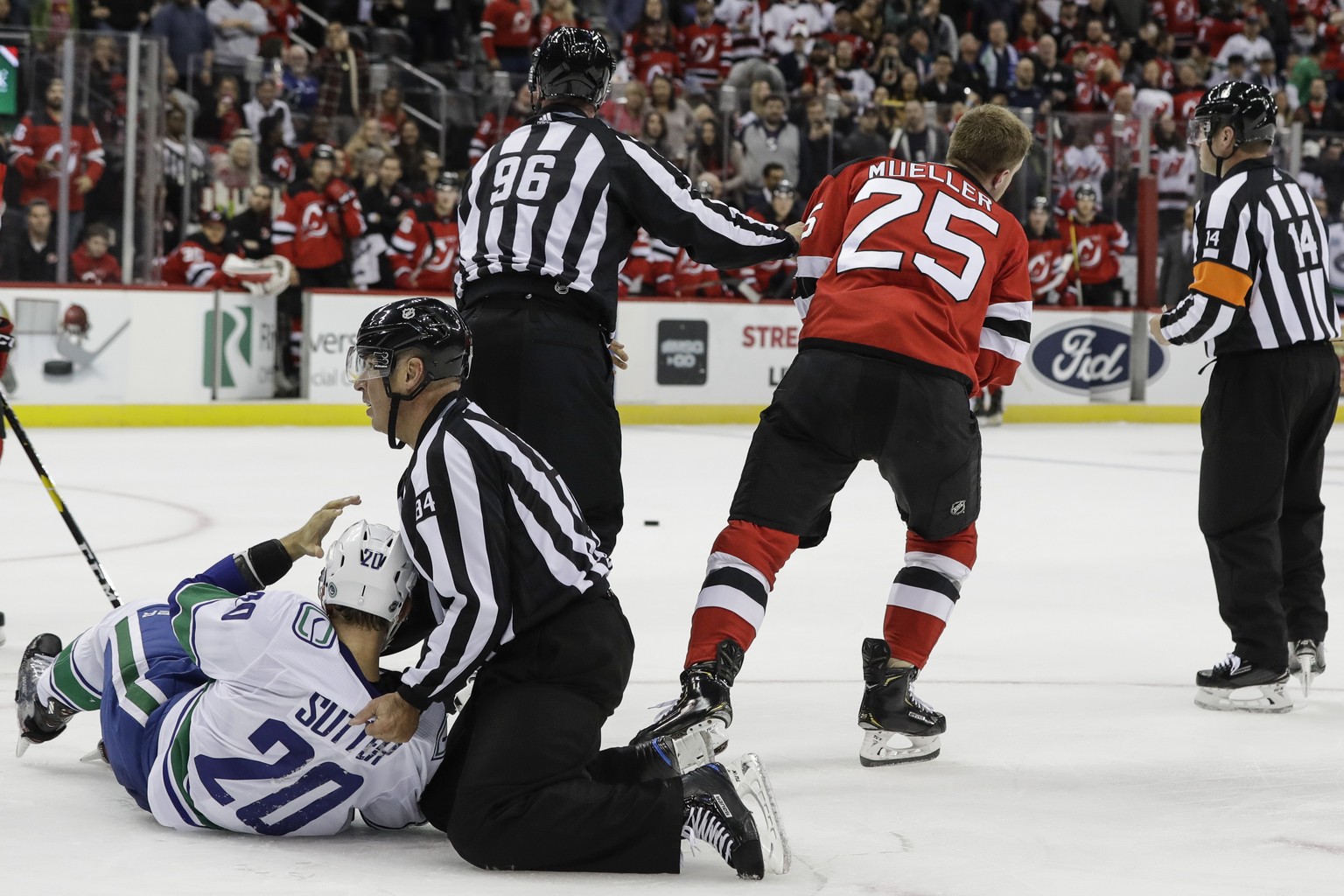 Referee&#039;s separate Vancouver Canucks&#039; Brandon Sutter (20) and New Jersey Devils&#039; Mirco Mueller (25) after a fight during the second period of an NHL hockey game Saturday, Oct. 19, 2019, ...
