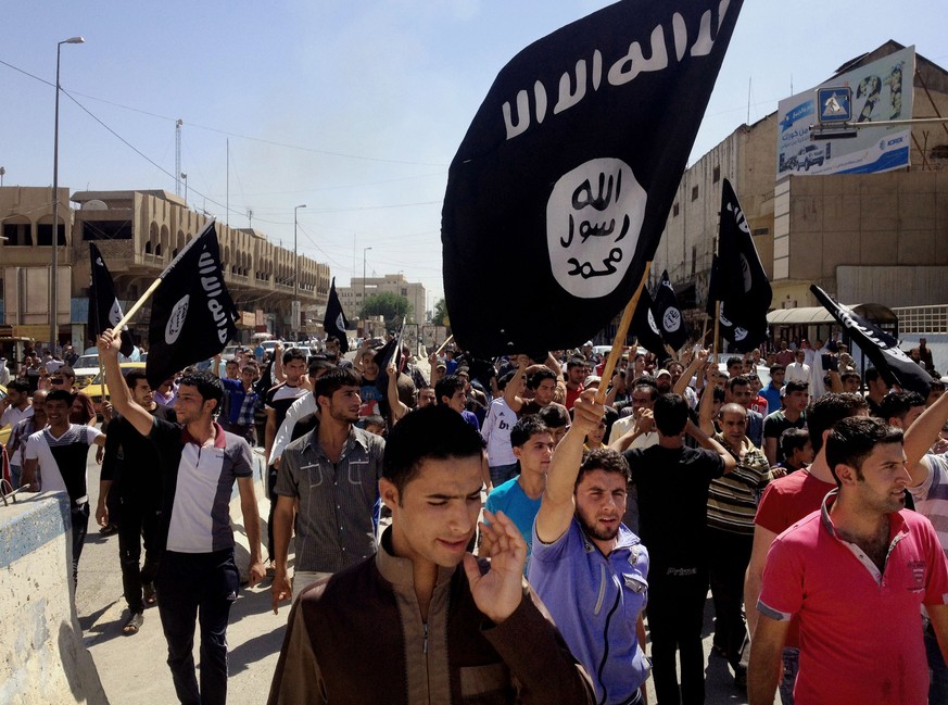 FILE - In this June 16, 2014 file photo, demonstrators chant pro-Islamic State group slogans as they carry the group&#039;s flags in front of the provincial government headquarters in Mosul, 225 miles ...