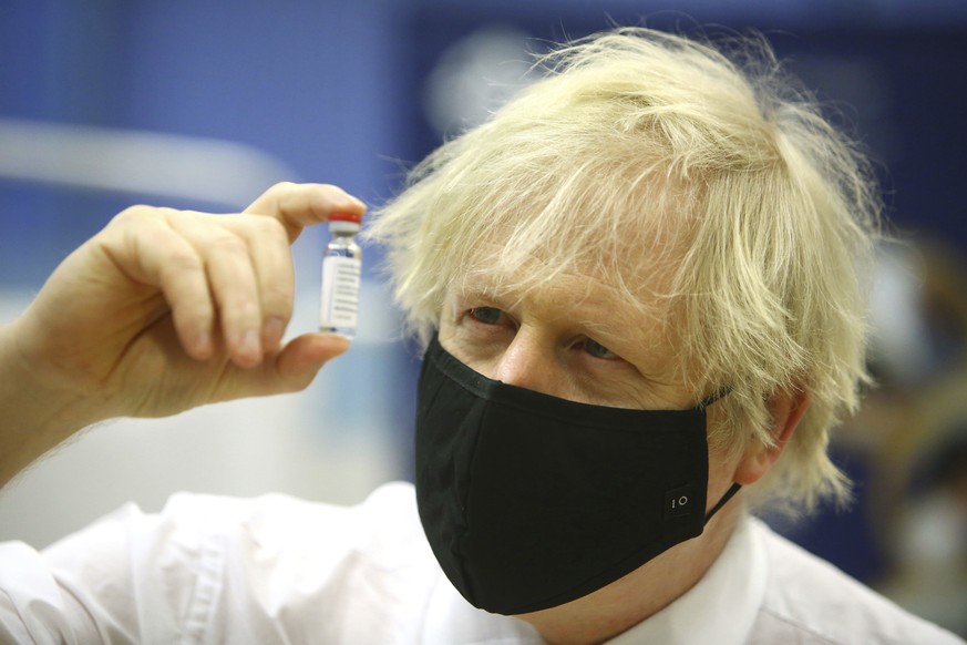 Britain&#039;s Prime Minister Boris Johnson holds a vial of the Oxford/Astra Zeneca Covid-19 vaccine at a vaccination centre in Cwmbran, south Wales, Wednesday Feb. 17, 2021. (Geoff Caddick/Pool via A ...