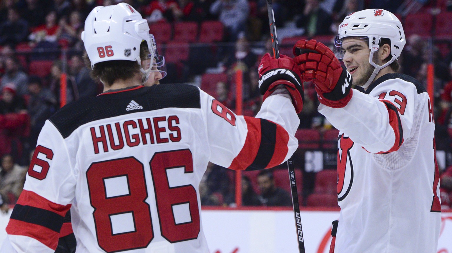 New Jersey Devils center Nico Hischier (13), right, celebrates his first-period goal with teammate Jack Hughes (86) during NHL hockey game action against the Ottawa Senators in Ottawa, Ontario, Sunday ...