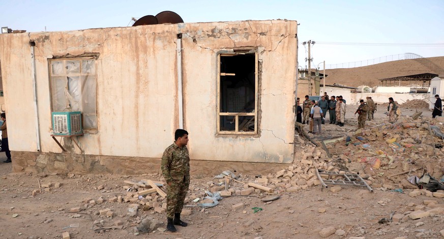epa09110022 Afghan security officials inspect the scene of a bomb blast that targeted a police checkpoint in Kamarkolagh area of Injil district, Herat province, Afghanistan, 01 April 2021. At least tw ...