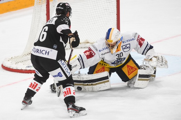 Lugano&#039;s player Mikkel Boedker, left, and Zug&#039;s goalkeeper Leonardo Genoni, during the preliminary match of the National League A (NLA) Swiss Championship 2020/21 between HC Lugano and EV ZU ...