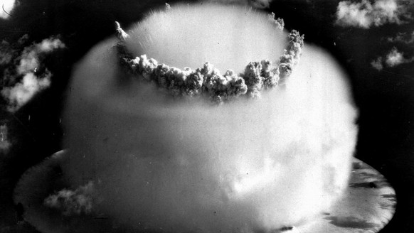 A huge mushroom cloud rises above Bikini atoll in the Marshall Islands July 25, 1946 following an atomic test blast, part of the U.S. military&#039;s &quot;Operation Crossroads.&quot; The dark spots i ...