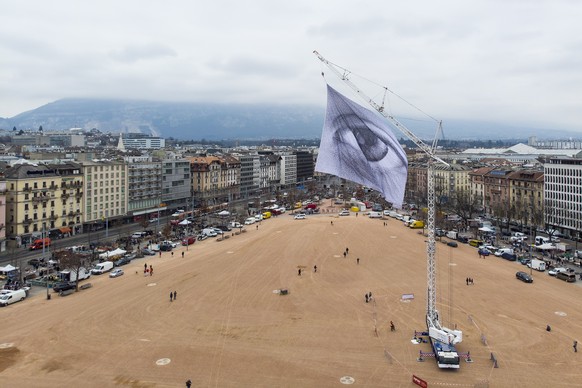 epa09056128 A photograph taken with a drone shows the giant flag &#039;We are watching: The Eyes of the world&#039; being hoisted in Geneva, Switzerland, 06 March 2021. The flag was designed by artist ...