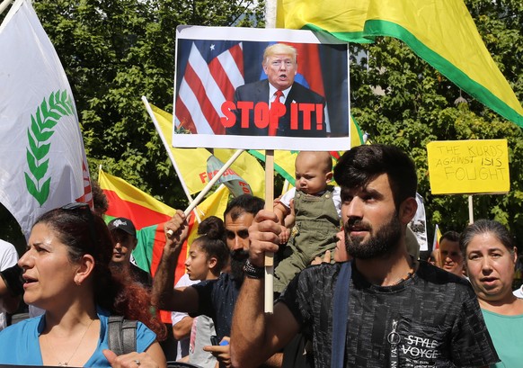 epa07909736 Kurdish people who live in Cyprus wave flags and shout slogans during a demonstration in solidarity with the Kurdish people outside of the USA embassy in Nicosia, Cyprus, 10 October 2019.  ...