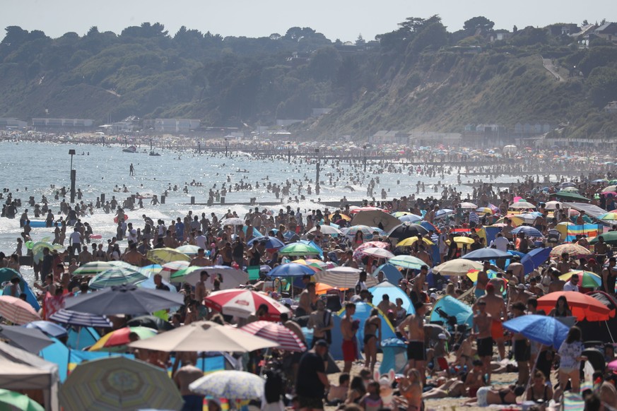 People are seen on the beach on the hottest day of the year, after an easing of social restrictions due to coronavirus, in Bournemouth, England, Wednesday, June 24, 2020. Temperatures reached 32.6C (9 ...