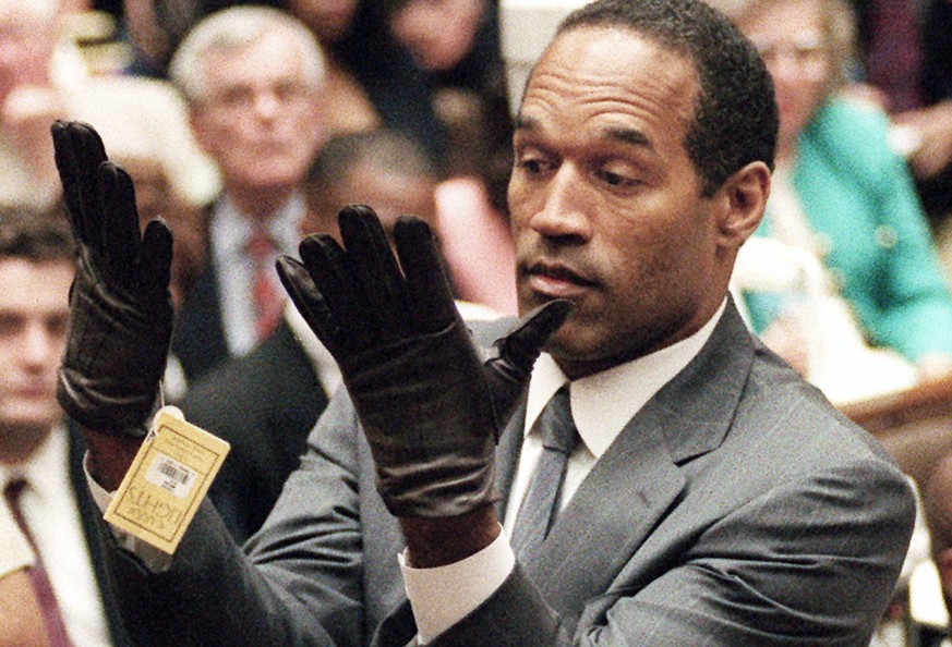 In this June 21, 1995 photo, O.J. Simpson holds up his hands before the jury after putting on a new pair of gloves similar to the infamous bloody gloves during his double-murder trial in Los Angeles.  ...