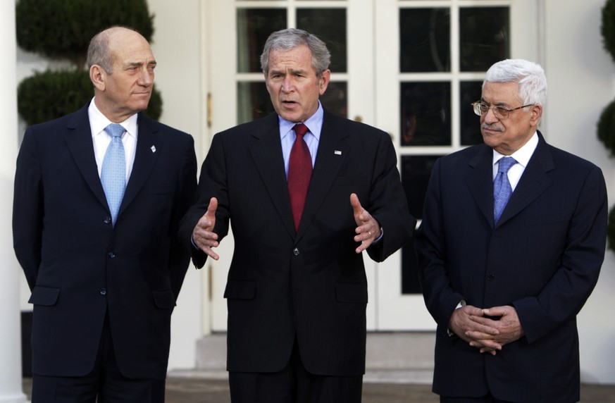 President Bush, center, flanked by Israeli Prime Minister Ehud Olmert, left, and Palestinian Authority President Mahmoud Abbas, right, makes a statement on the Middle East peace process in the Rose Ga ...