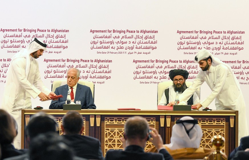 epa08259575 US Special Representative for Afghanistan Reconciliation Zalmay Khalilzad (2-L) and Taliban co-founder Mullah Abdul Ghani Baradar (2-R) sign the US-Taliban peace agreement during a ceremon ...