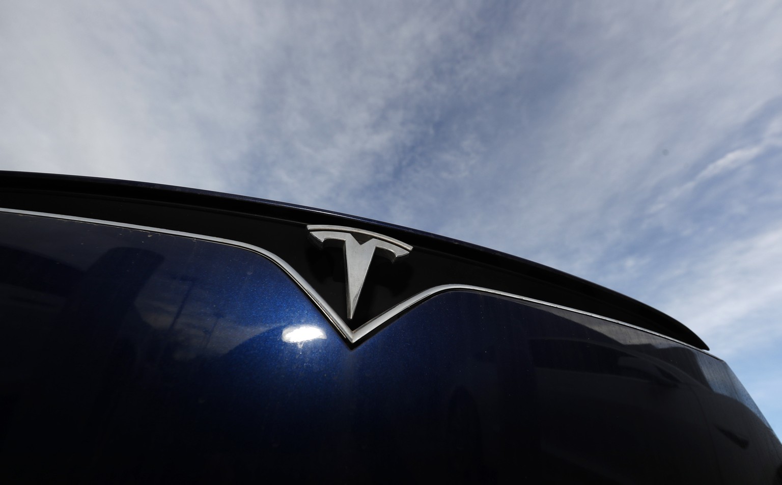FILE - In this Nov. 10, 2019, file photo the company logo shines off the grille of an unsold 2020 Model X at a Tesla dealership in Littleton, Colo. Tesla will be able to sell and service its vehicles  ...