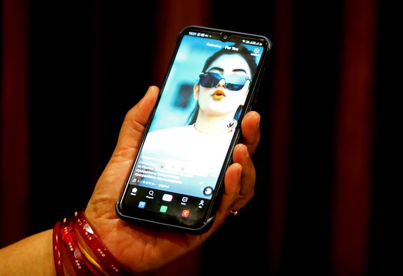 epa08516564 A woman watches a short video on the Chinese video-sharing app TikTok on her smartphone, in Bhopal, central India, 29 June 2020. India&#039;s national government in New Delhi has announced ...