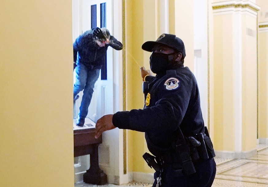 A U.S. Capitol police officer shoots pepper spray at a protestor attempting to enter the Capitol building during a joint session of Congress in Washington, DC on Wednesday, January 6, 2021. PUBLICATIO ...