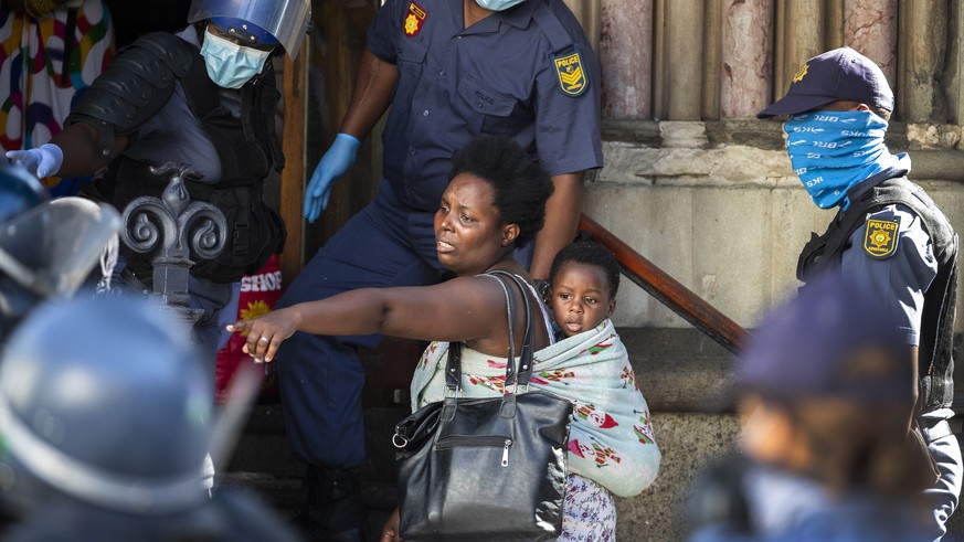 epaselect epa08339209 A mother and child, part of a group of African foreign nationals from various African countries, are moved by South African police out of the Central Methodist Church where they  ...