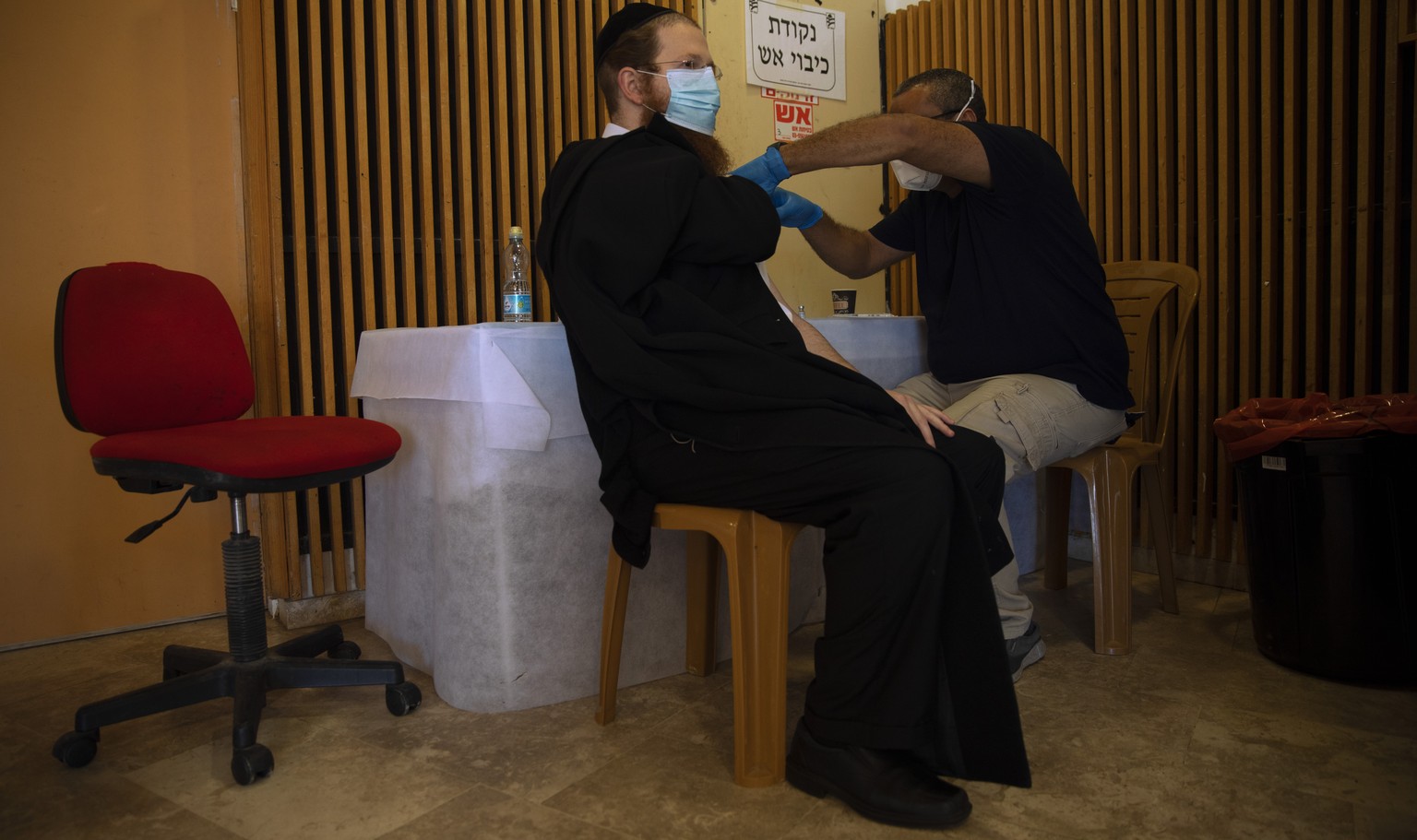 An ultra-Orthodox Jewish man receives a Pfizer-BioNTech coronavirus vaccine at a COVID-19 vaccination center in the West Bank Jewish settlement of Givat Zeev, near Jerusalem, Monday, Feb. 1, 2021. (AP ...