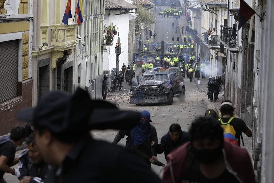Protesters run from an oncoming armored vehicle and riot police during clashes in downtown Quito, Ecuador, Wednesday, Oct. 9, 2019. Ecuador&#039;s military has warned people who plan to participate in ...