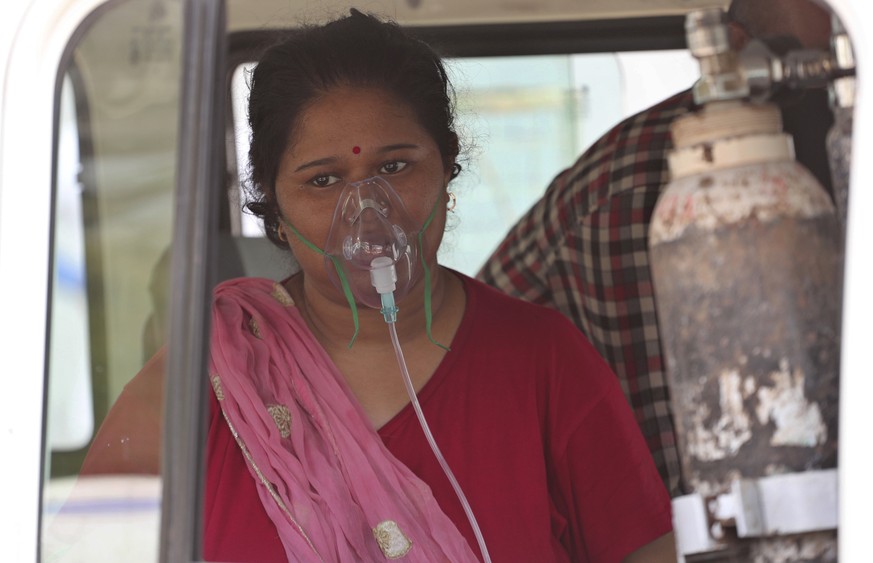 A COVID-19 patient wearing oxygen mask waits inside a vehicle to be attended and admitted in a dedicated COVID-19 government hospital in Ahmedabad, India, Thursday, April 22, 2021. India reported a gl ...