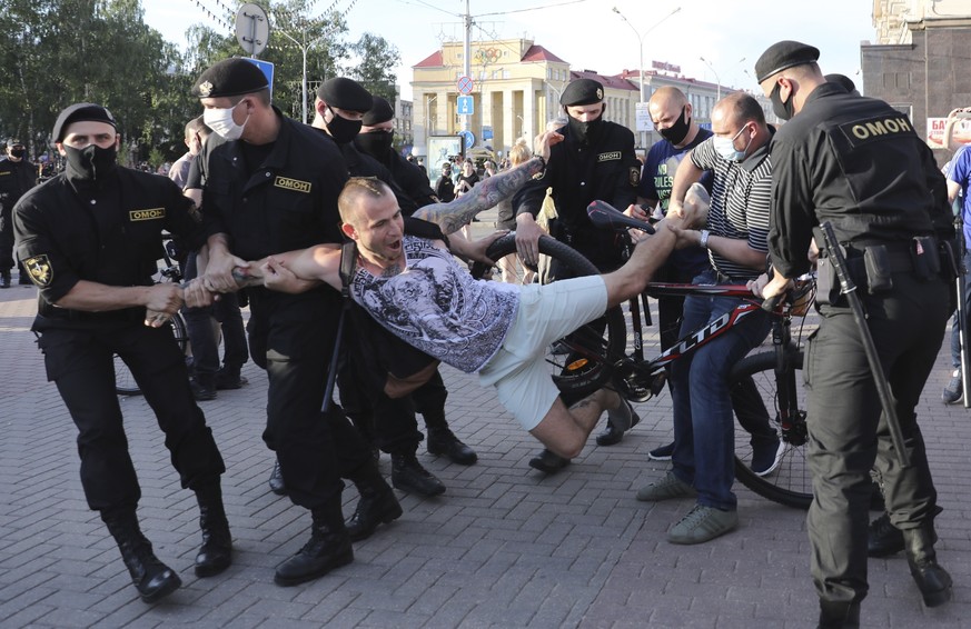 Police officers wearing protective face masks detain a protester during a rally in Minsk, Belarus, Friday June 19, 2020. The President of Belarus said Friday that his government thwarted a foreign-ins ...